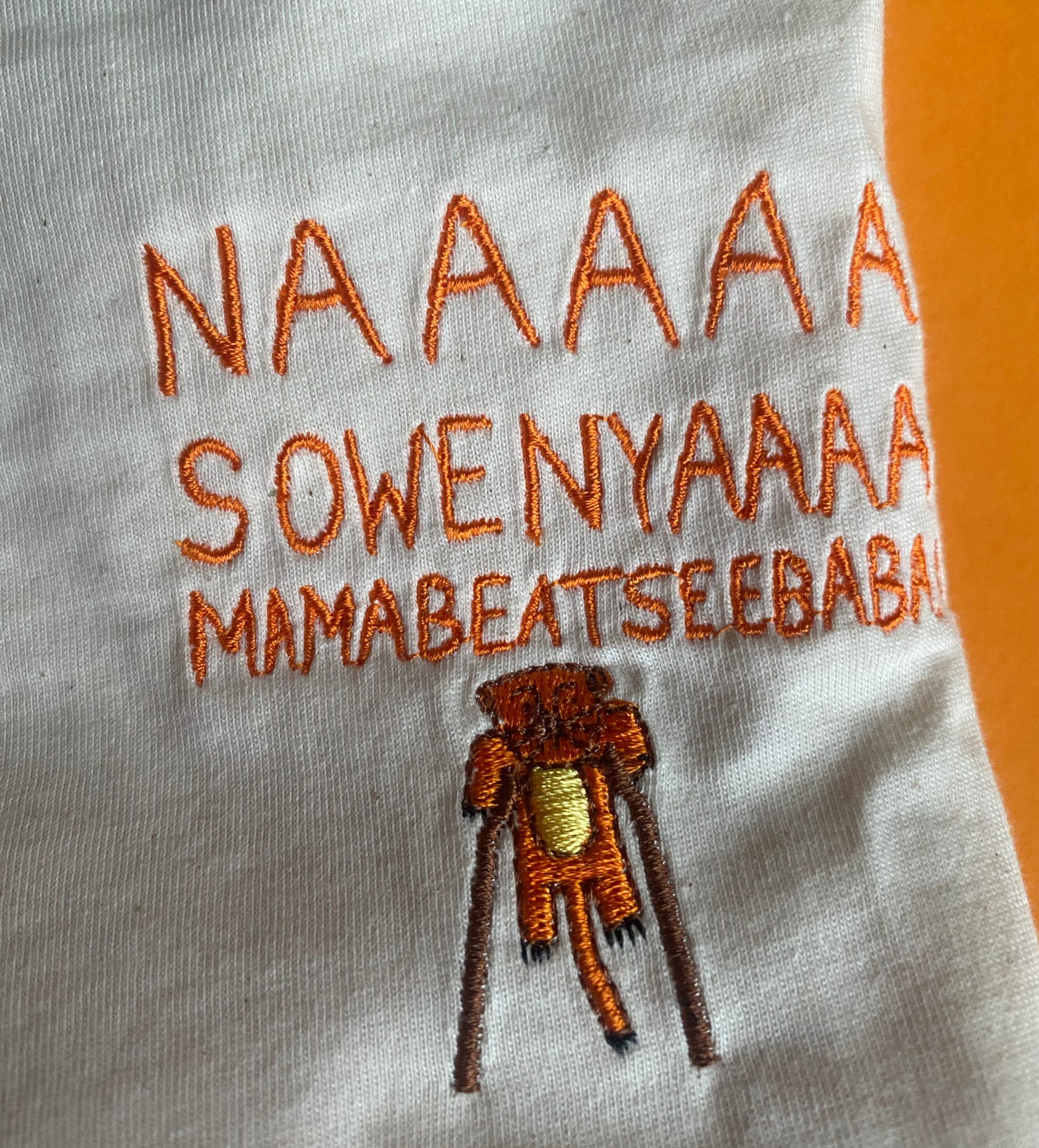 Individuelle Stickerei mit Schriftzug und Motiv auf weißem Stoff